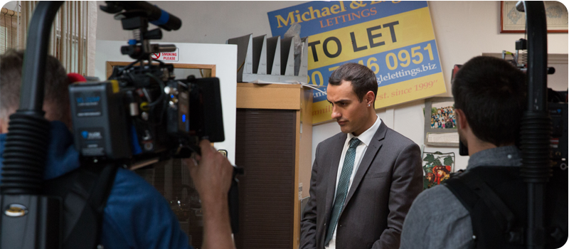 Behind the scenes on Stath Lets Flats, inside an estate agents set with two cameras pointed at the lead actor ready for a take.
