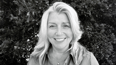 Headshot: Juliette Squair, a woman with light, blonde hair styled to the side, wearing a shirt and necklace.