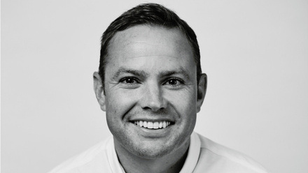 Headshot: Paul Hillier, a man with short, dark hair wearing a white shirt.