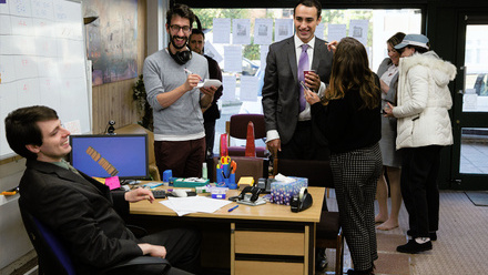 Behind the scenes on Stath Lets Flats, inside an estate agents set with crew members alongside cast between takes.