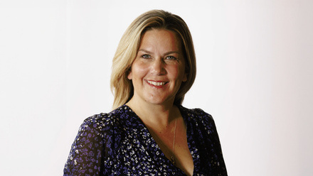 Headshot: Kim Osbourne, a woman with straight, blonde hair wearing a patterned blouse.