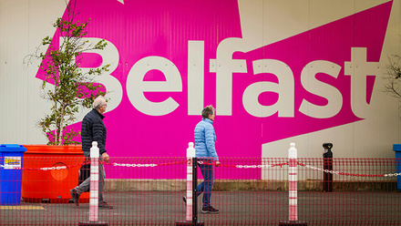 Photograph of a wall with pink and white artwork reading 'Belfast.'