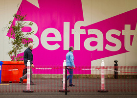 Photograph of a wall with pink and white artwork reading 'Belfast.'