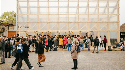 A large crowd of people walking around outside a building.