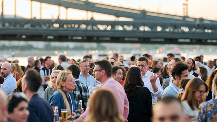 People networking outdoors next to the river Danube at NAPTE Budapest.
