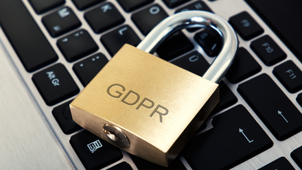 Close up image of a laptop keyboard with a padlock engraved with the letters GDPR on it.