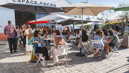 Sunny Side of the Doc 2025 meetings on tables outdoors with parasols sheltering delegates from the sun.