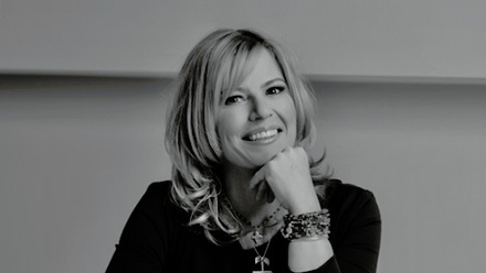 Headshot: Jannine Waddell, a woman with short, layered hair wearing a black top and jewellery.