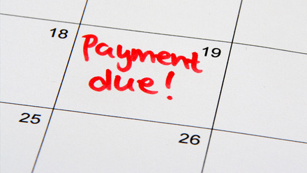 A close up on a calendar with the words 'Payment Due!' in red pen in the box for the 19th of the month.