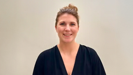 Headshot: Hilary Rossborough, a woman with a blonde hair styled in a bun wearing a black blouse.