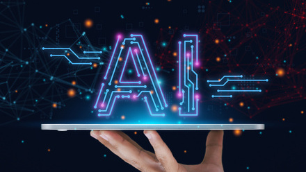Image in blues and pinks of the letters AI in a futuristic font hovering above a tablet which is being held up horizontal by a hand.