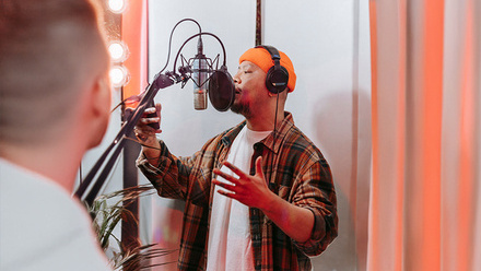 Voiceover Narrator recording vocals in a modern recording studio.