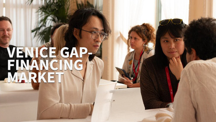 Venice Gap-Financing Market attendees sat down at a table having a meeting. 