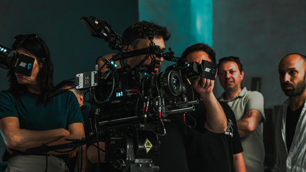 Film crew working together operating advanced equipment on set.