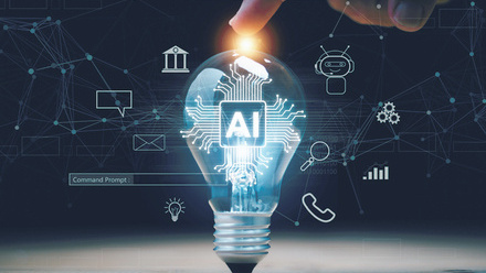 Computer-generated image of a lightbulb being held up on a desk by a finger with the letters AI in the centre and various icons around it.