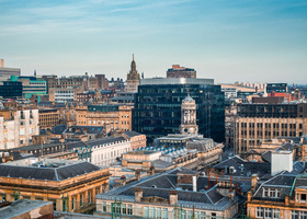 A rooftop view of the mixed architecture of old and new buildings in Glasgow city in late afternoon light.