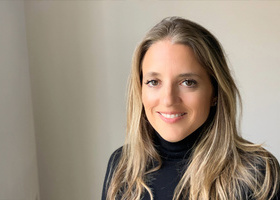 Headshot: Rachel Vecht, a woman with long blonde hair wearing a black turtleneck top.