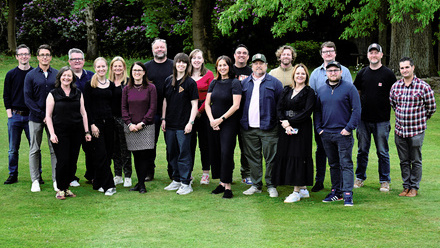 Group photo of the Future North East cohort pictured in a field with trees behind them.