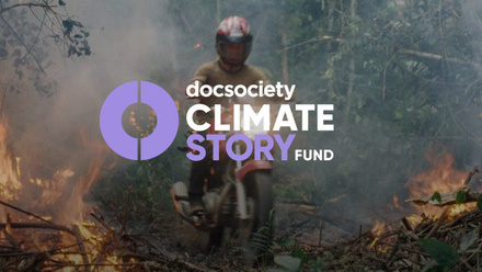 Person wearing a helmet riding a motorbike through a burning forest with an overlay of the Doc Society Climate Story Fund logo in white and purple.