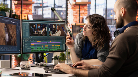 Creative team of editors collaborating on a movie montage project, using AI chatbot and post production software.