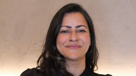 Headshot: Anushka Sinha, a woman with long dark hair wearing a black top.