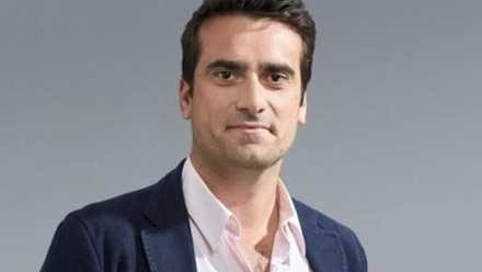 Headshot: Lucas Green, a man with short dark hair wearing a navy jacket and white shirt.