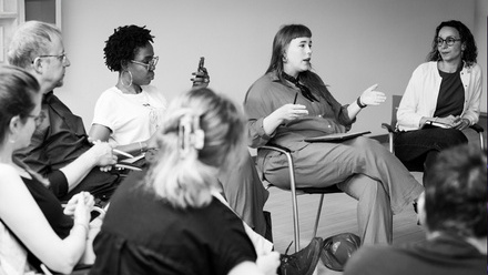 A black and white image of four producers talking at an EAVE Producer Workshop.