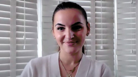 Headshot: Imelda Vyshka, a woman with dark brown hair slicked back into a ponytail wearing a cream blouse.