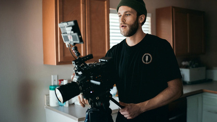 Director operating a camera in a home setting.