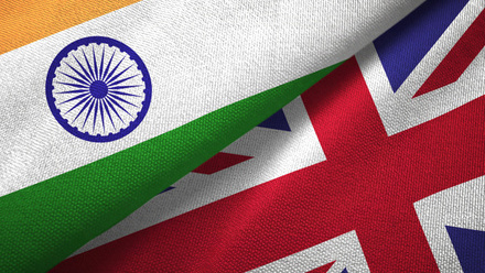Close-up of the Indian and British flags folded together, the fabric texture is visible.