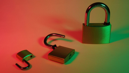 An image of three gold padlocks on a green and red gradient background.