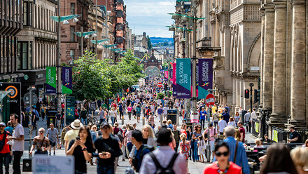 Photograph of a sunny day in Glasgow with people walking up and down Buchanan Street.