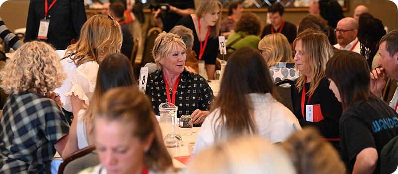 A group of delegates wearing red lanyards sat around a table at Pact's Content Without Borders 2026.