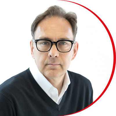 Headshot: Nigel Warner, a man with short brown hair wearing dark-framed glasses and a white shirt.