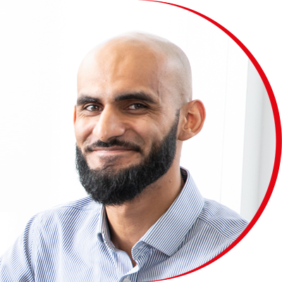 Headshot: Irteza Ahmad, a man with a short, dark beard wearing a light blue shirt.