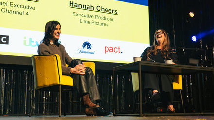 Channel 4 CEO, Priya Dogra on stage being interviewed at the Creative Cities Convention, with a large screen behind her.