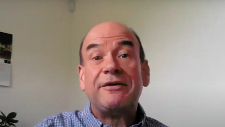 Headshot: Mark Fenwick, a man with dark brown sideburns wearing a blue checked shirt.