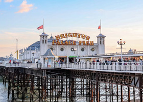 Landscape image of Brighton Pier in front of a blue sky. 